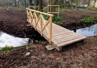 Inserat Fußgängerbrücke mit Baumumrandungen 